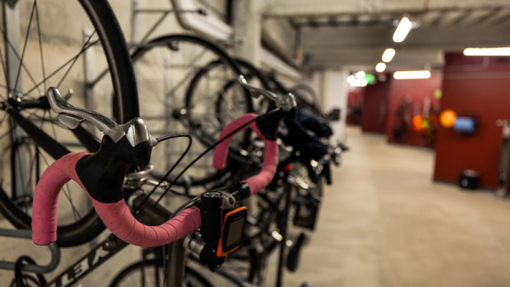 A close up of a bike rack with a pink bike in focus