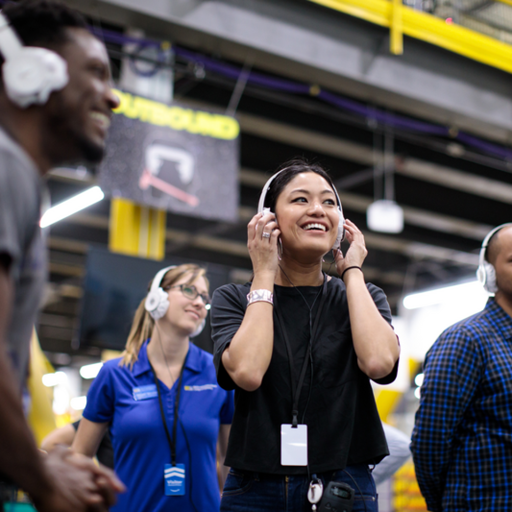 Guests in a Fulfillment Center with headsets on