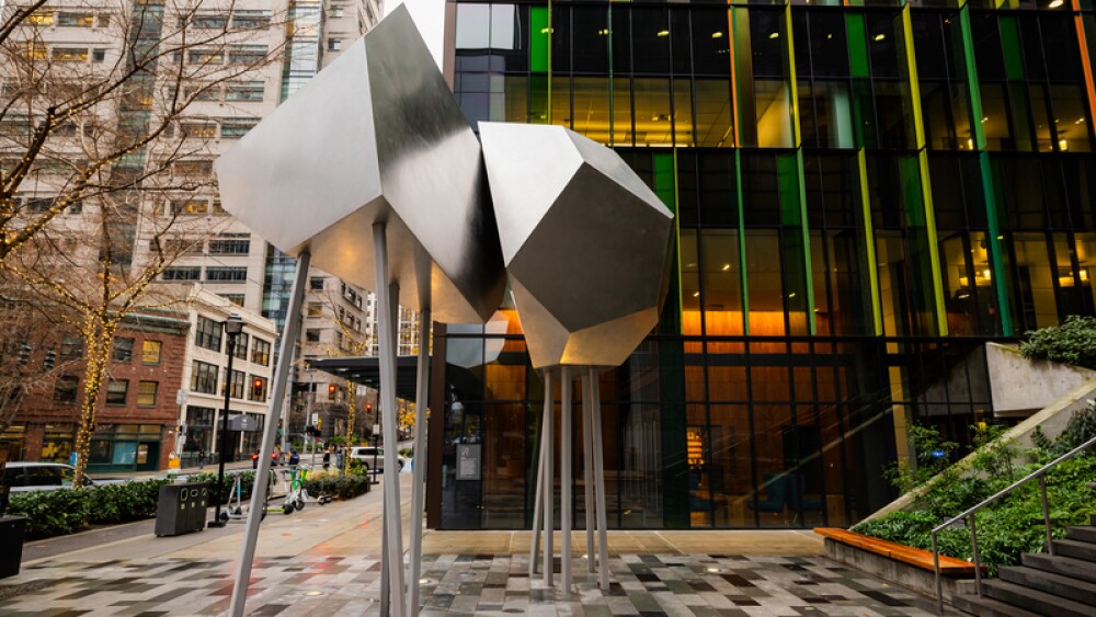 A metal geometric sculpture sits in front of a staircase