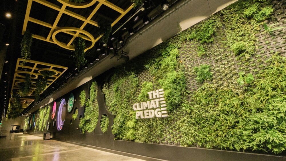 A large living wall with the words "The Climate Pledge" in the center